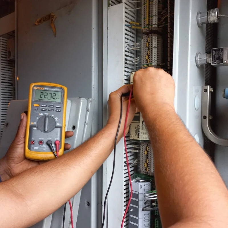 Technician calibrating instrumentation with a multimeter